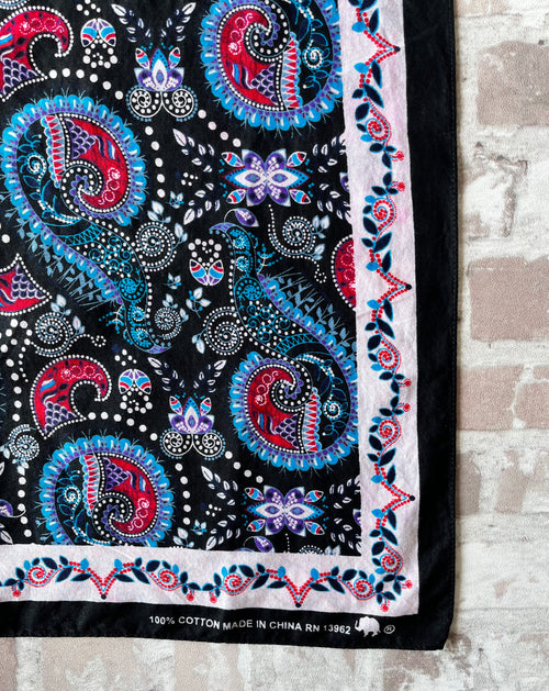 Bandana en coton vintage des années 90 au motif Paisley psychédélique turquoise et rouge sur fond noir, présenté plié à plat. / détail impression éléphant et code RN