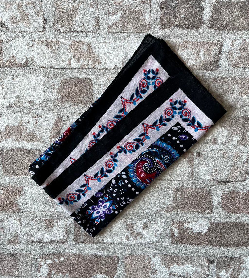 Bandana en coton vintage des années 90 au motif Paisley psychédélique turquoise et rouge sur fond noir, présenté plié à plat.