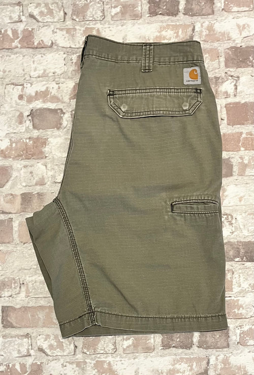 Short cargo gris-beige Carhartt Ripstop plié à plat, mettant en avant le tissage quadrillé et la patine d'usage sur la poche.