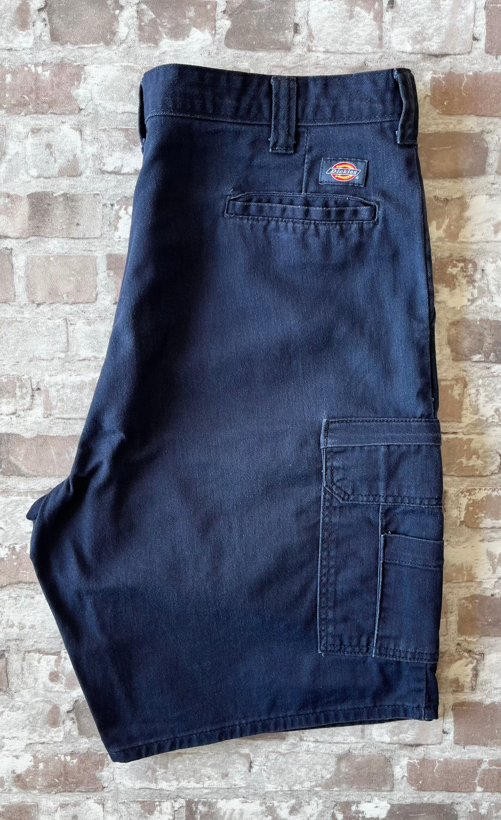 Short cargo bleu marine Dickies Relaxed Fit en toile de coton canvas avec grandes poches latérales, présenté à plat.