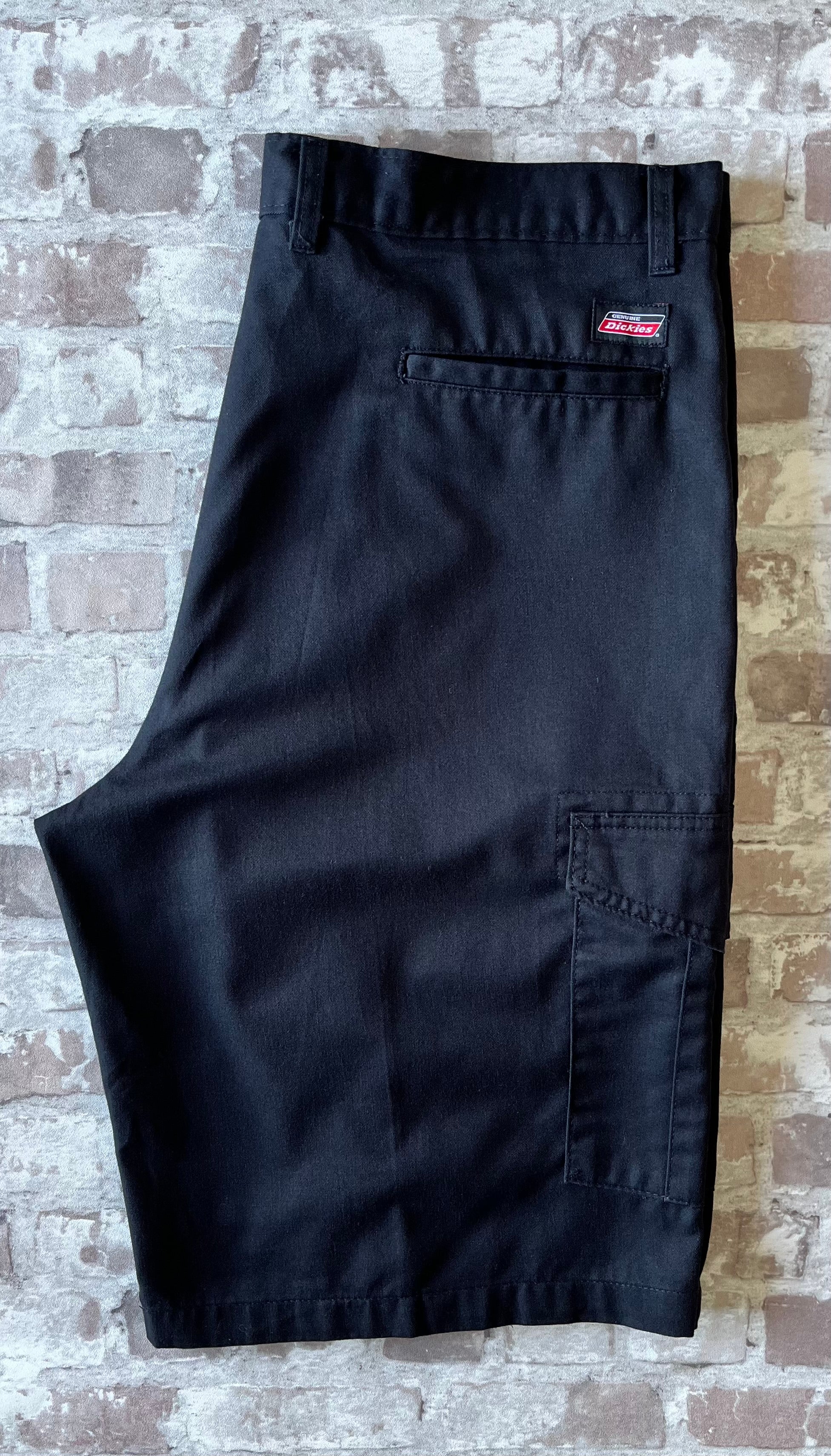 Short cargo noir Dickies Loose Fit avec grandes poches latérales à soufflets et rabats velcro, présenté à plat.