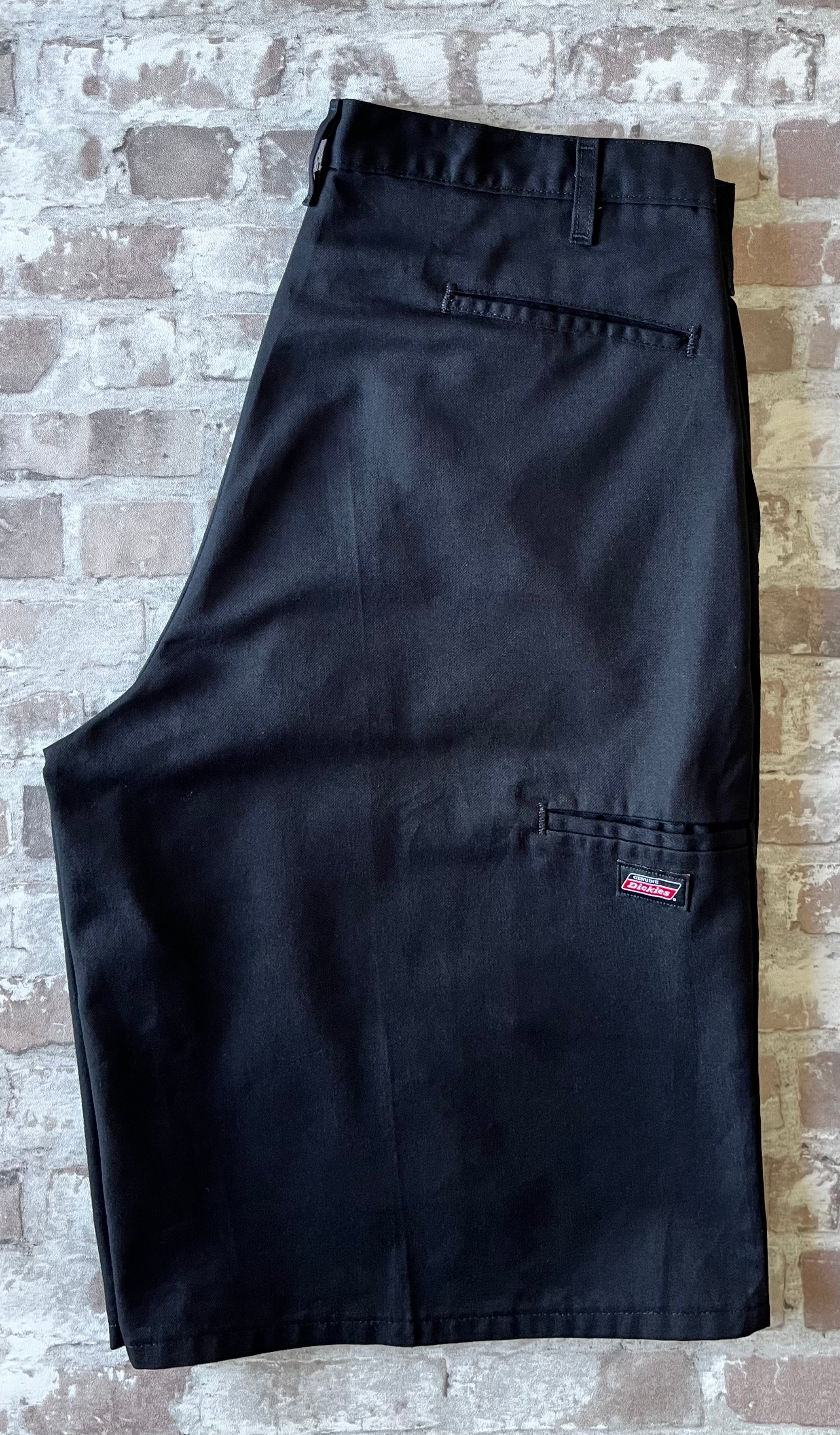 Short de travail Dickies 13 pouces Loose Fit noir avec plis permanents et poche téléphone latérale, présenté à plat.