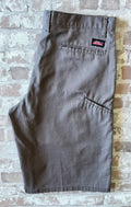 Short cargo asymétrique Dickies gris étain avec une seule poche latérale sur la jambe droite, présenté à plat.