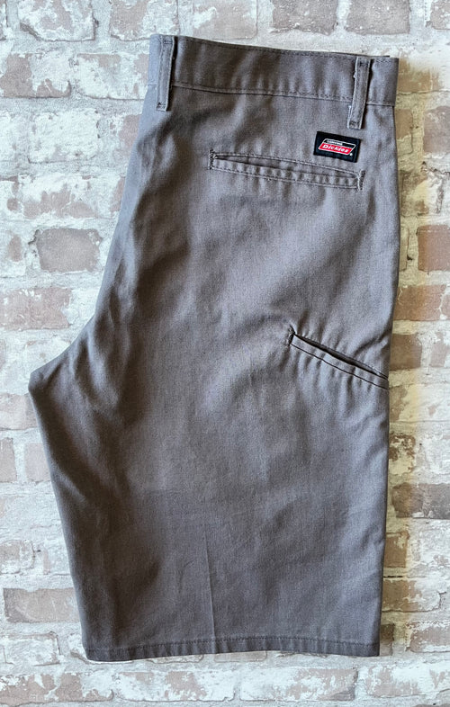 Short cargo asymétrique Dickies gris étain avec une seule poche latérale sur la jambe droite, présenté à plat.