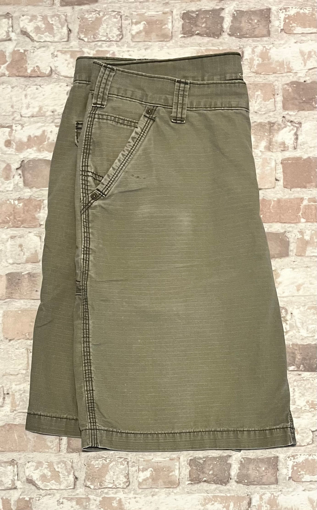 Gros plan sur la patine d'usage sur la jambe d'un short cargo Carhartt de seconde main.
