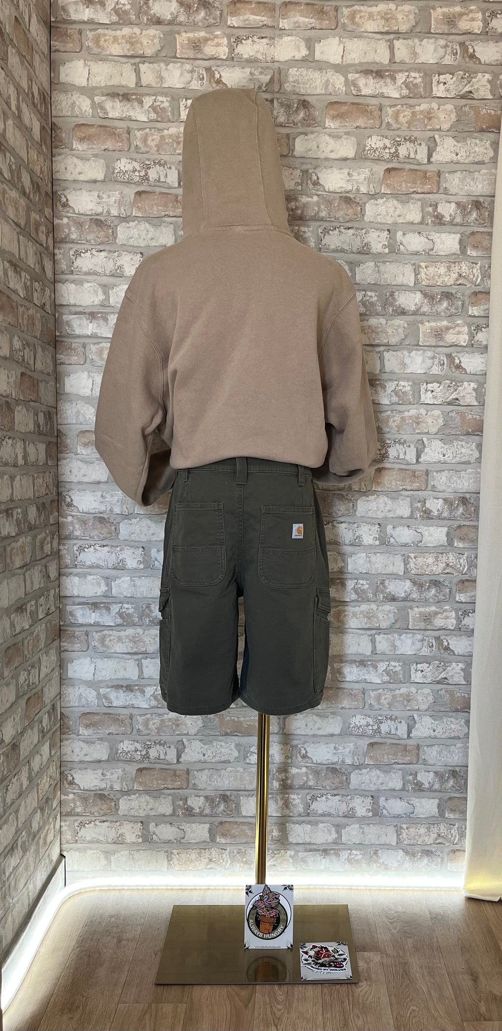 Hoodie Nike Sportswear beige sable avec logo brodé blanc porté avec un short bermuda cargo Carhartt Rugged Flex court et Patchs La Barbuda, de dos
