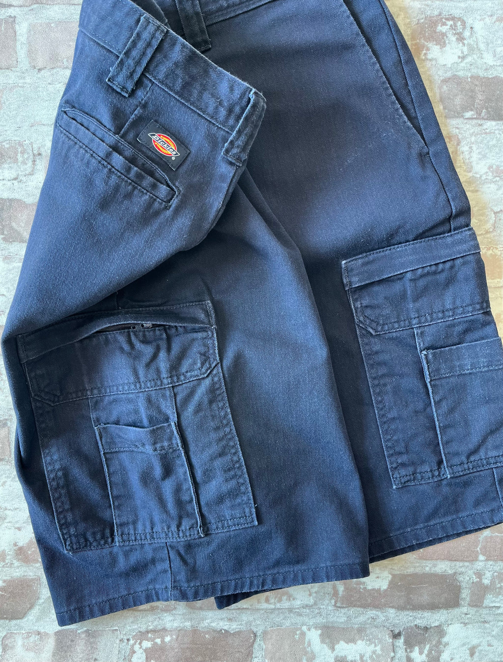 Short cargo bleu marine Dickies Relaxed Fit en toile de coton canvas avec grandes poches latérales, présenté à plat.