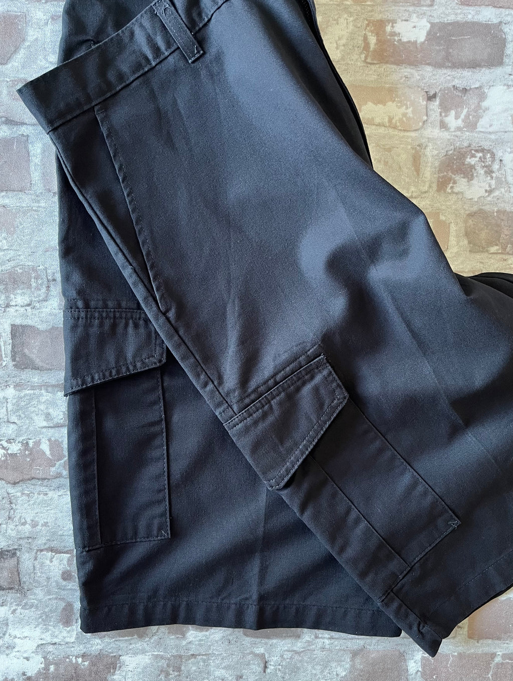 Short cargo noir Dickies Loose Fit avec grandes poches latérales à soufflets et rabats velcro, présenté à plat.