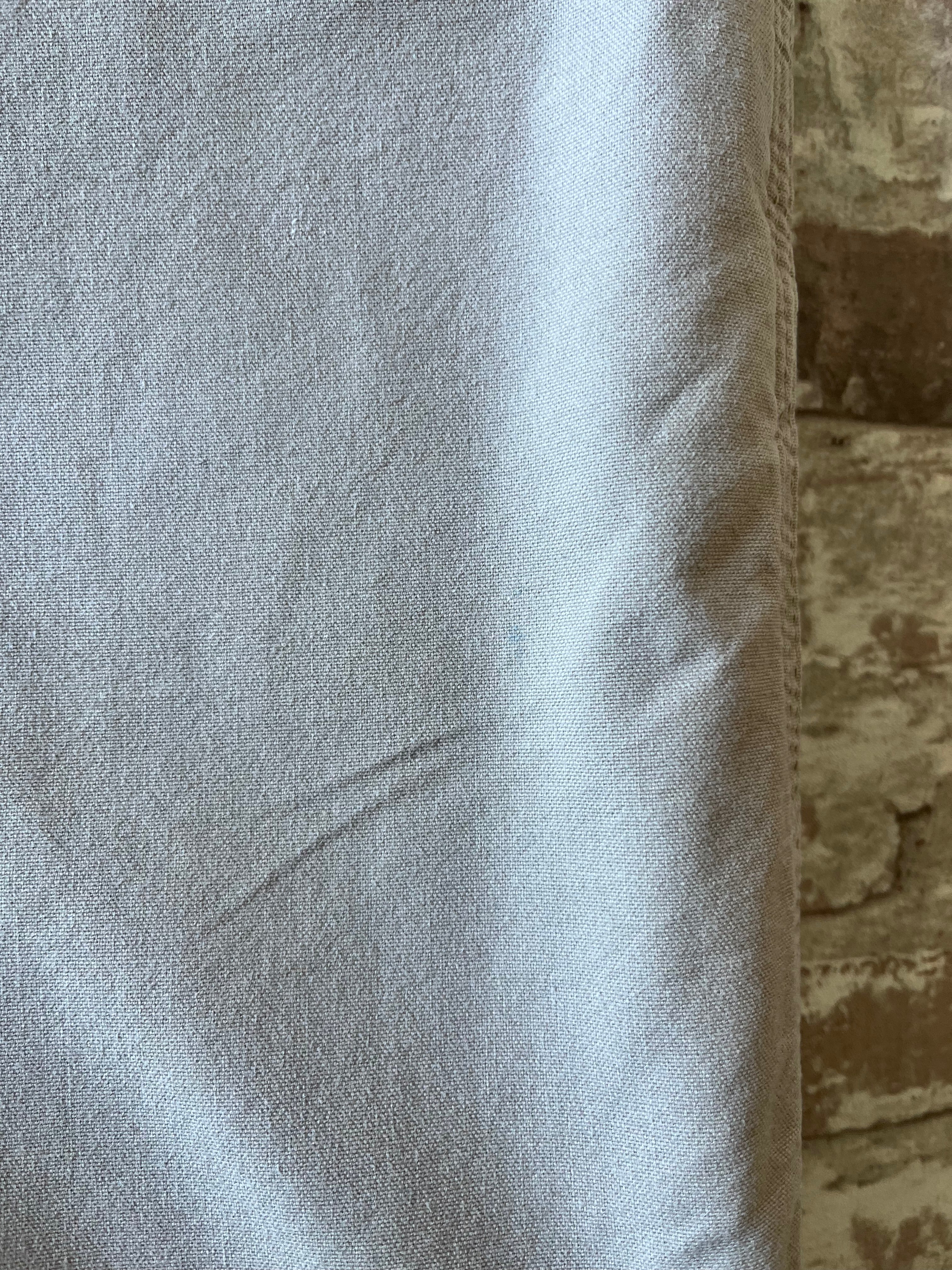Gros plan sur des micro-taches de surface très discrètes situées sur la toile de coton beige d'un short Carhartt.