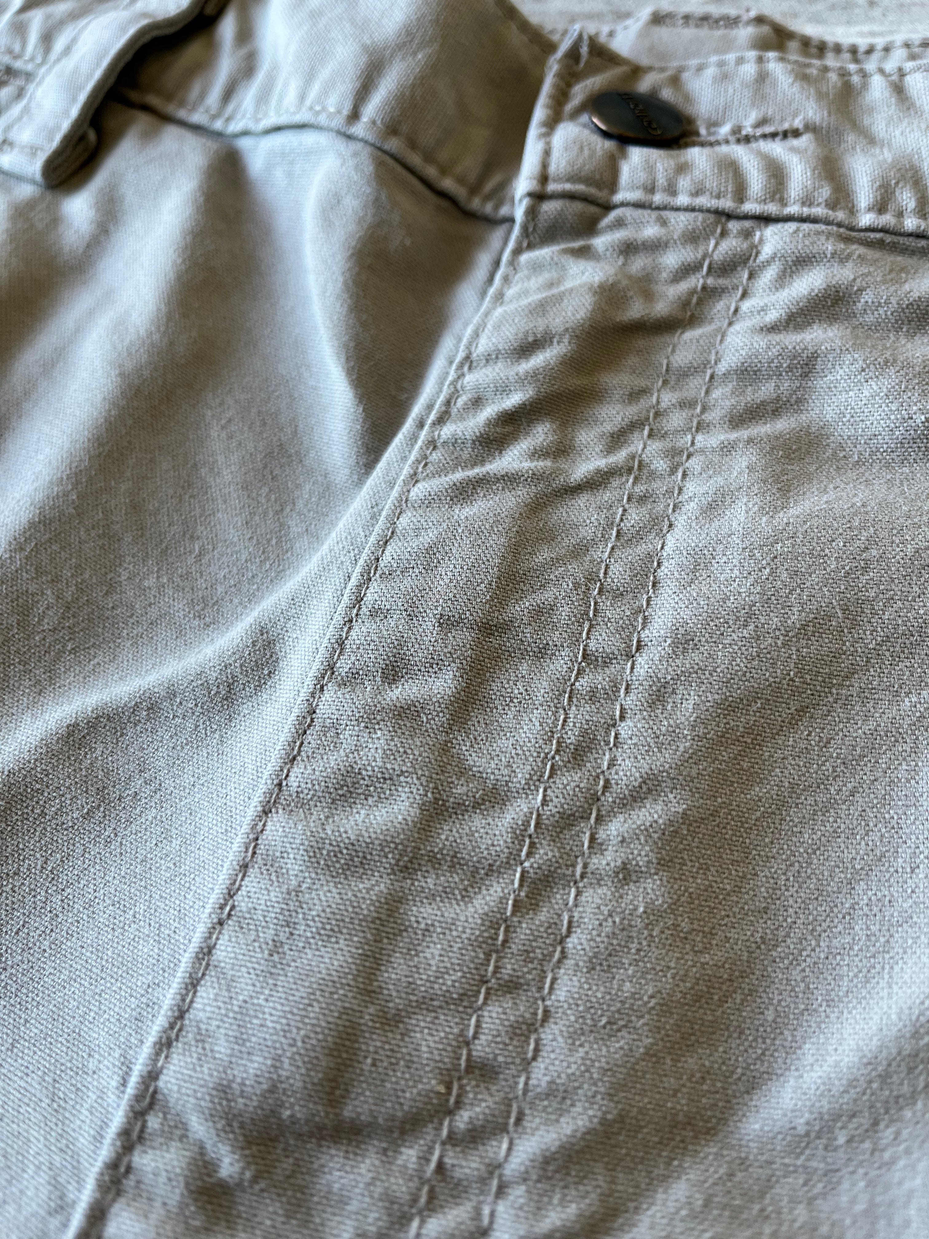 Gros plan sur des micro-taches de surface très discrètes situées sur la toile de coton beige d'un short Carhartt.