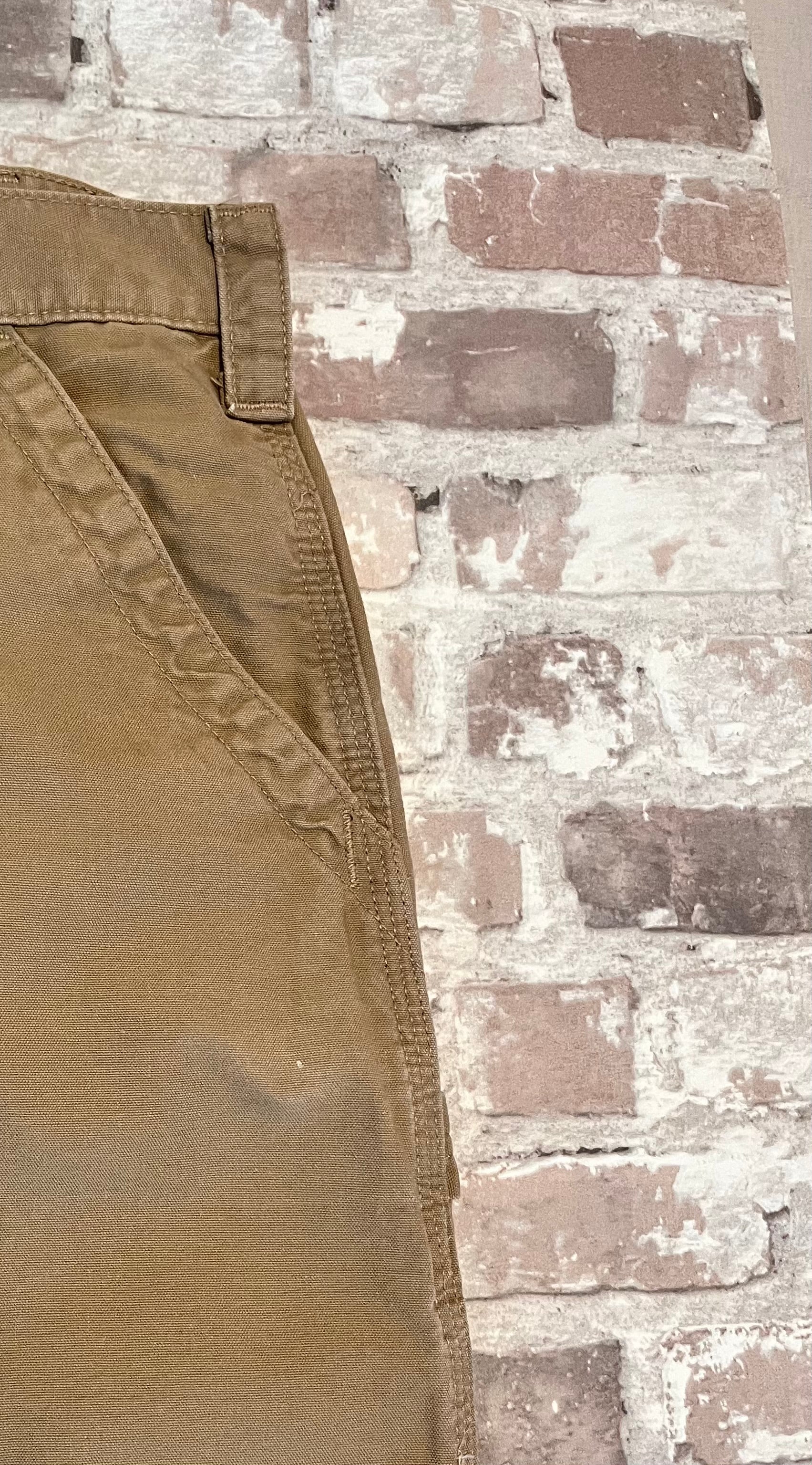 Short de travail DKH Carhartt B147 à plat, mettant en valeur la toile en coton canvas et montrant une tache proche d' une poche.