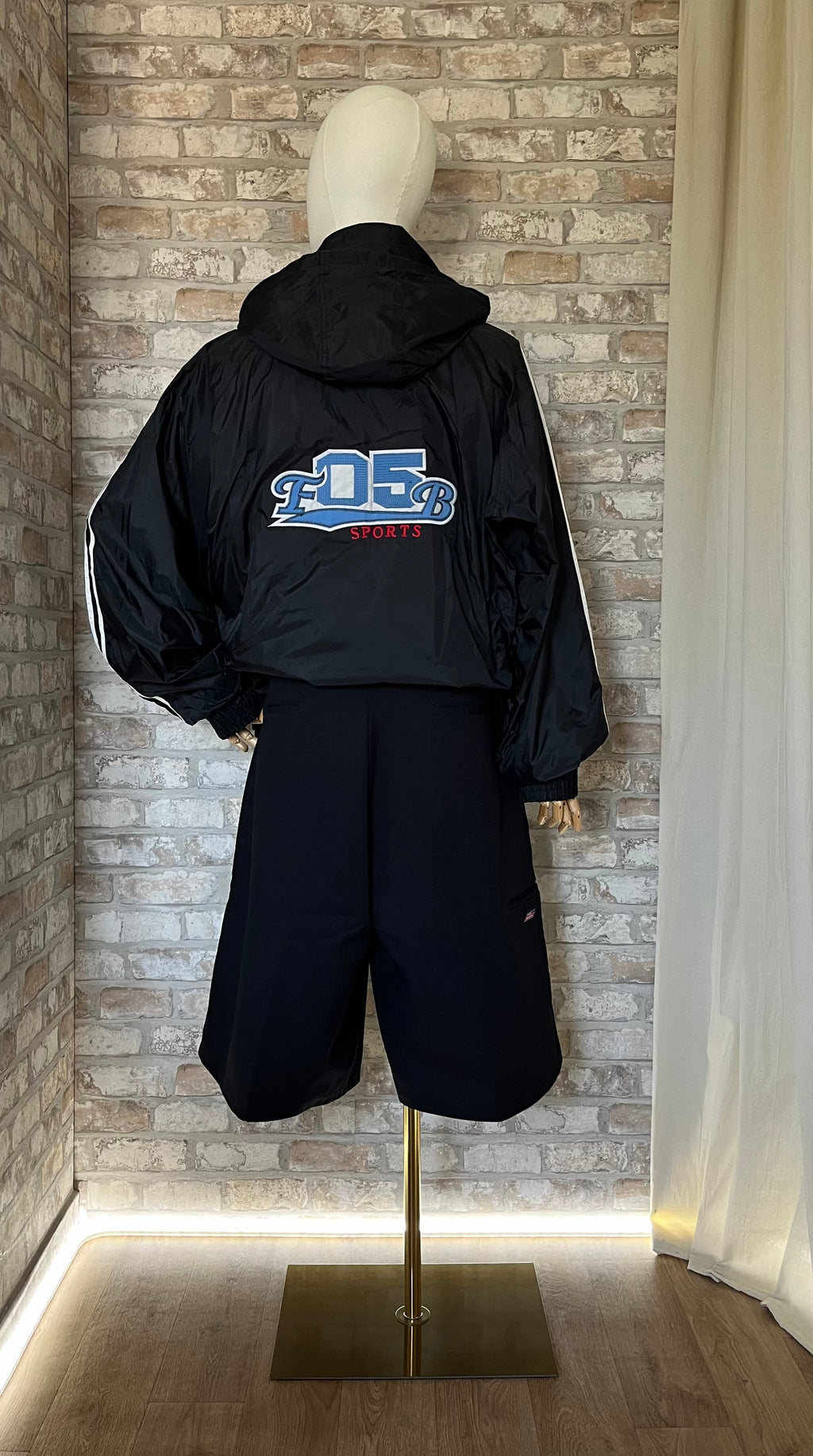 Bermuda Dickies , 13" Loose Fit - Noir  porté sur un mannequin de dos avec coupe vent Vintage.