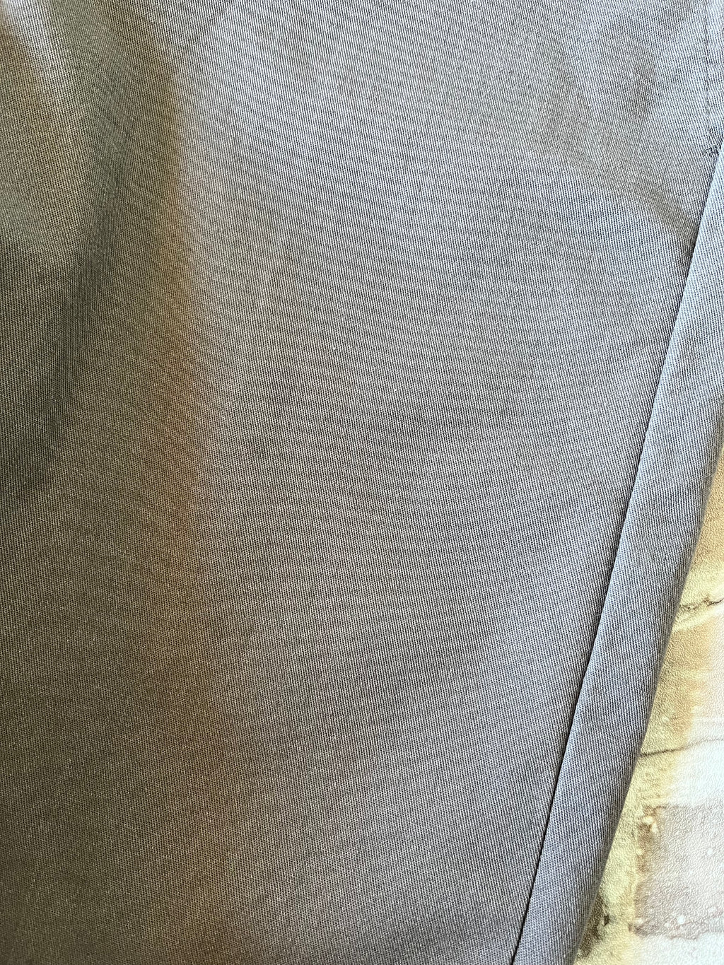 Gros plan sur les légères taches sombres discrètes sur la jambe gauche d'un bermuda Dickies de seconde main.