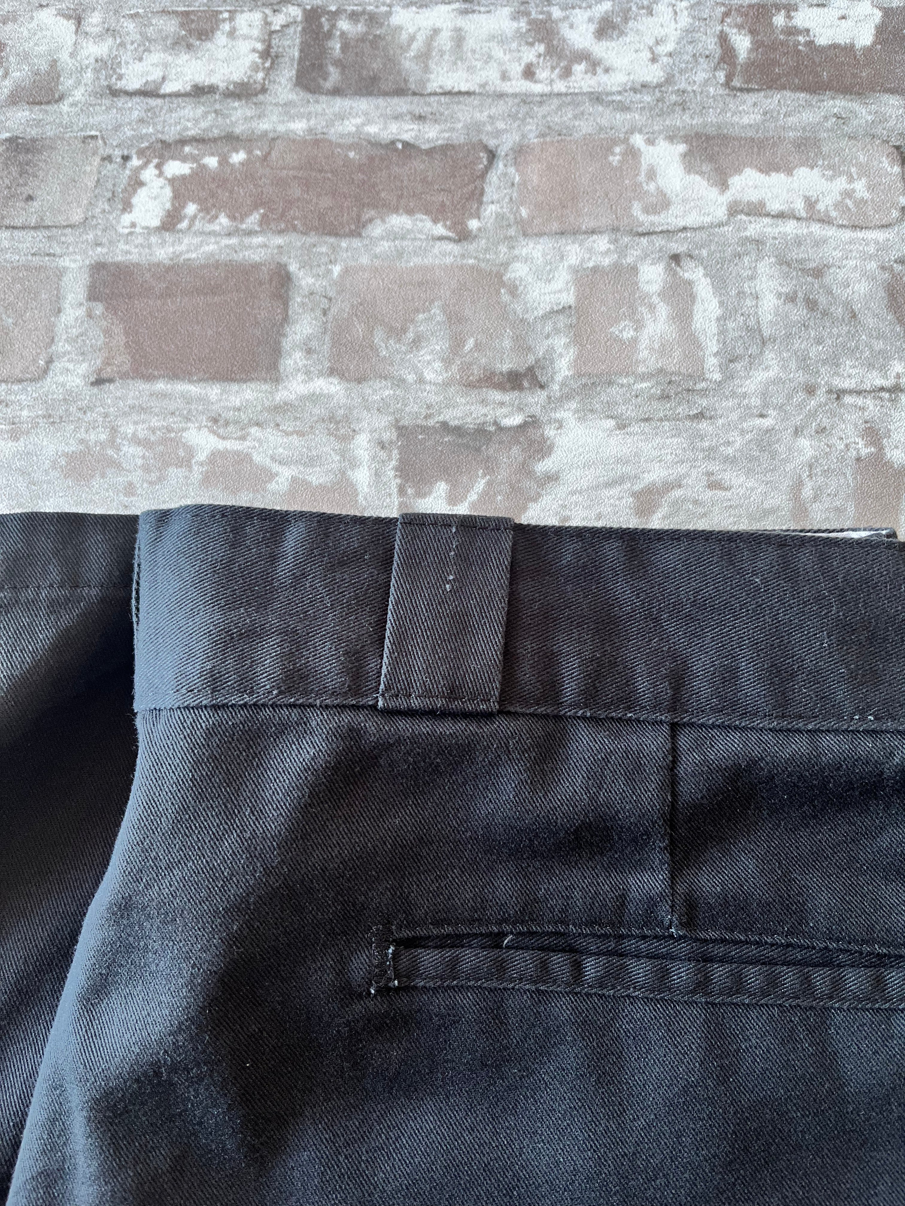 Gros plan sur une légère marque de frottement sur le passant de ceinture d'un short Dickies noir.