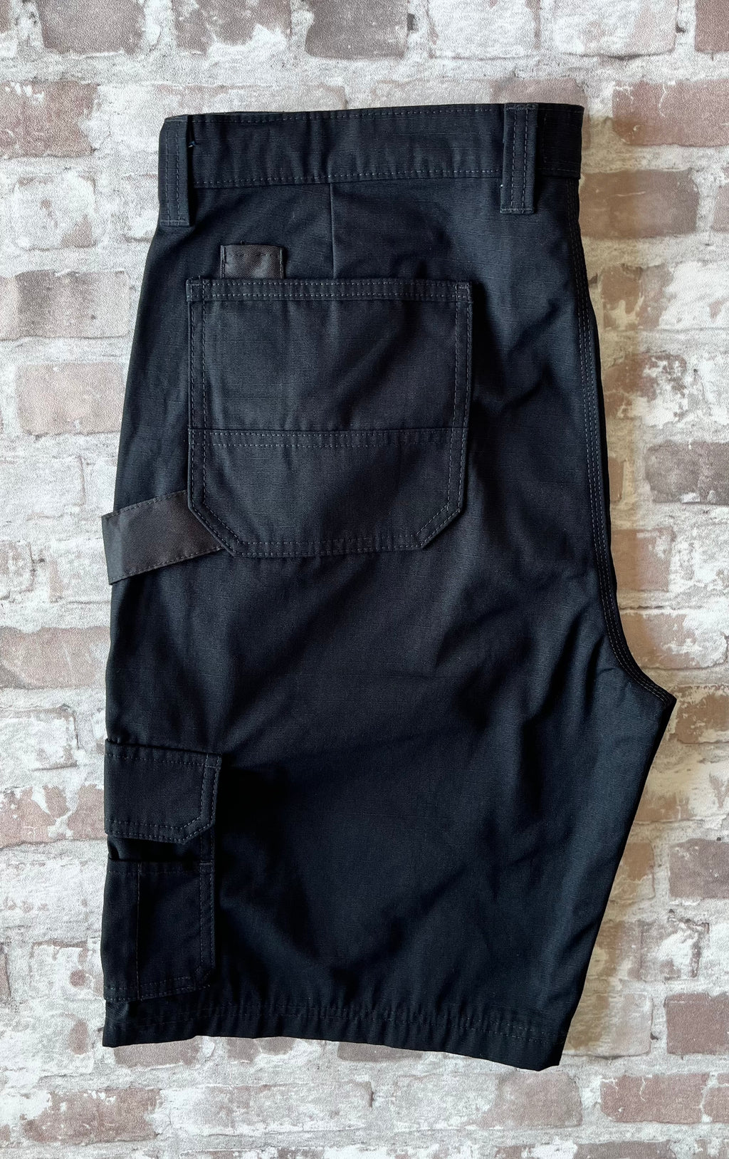 Short cargo noir en toile Ripstop Genuine Dickies avec boucle marteau et poches latérales à soufflets, présenté à plat.