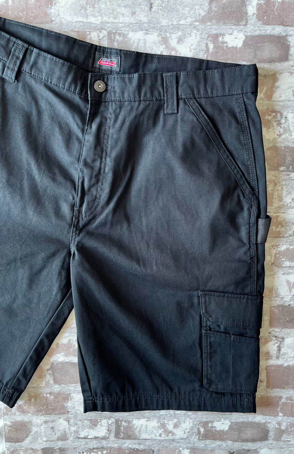 Short cargo noir en toile Ripstop Genuine Dickies avec boucle marteau et poches latérales à soufflets, présenté à plat.