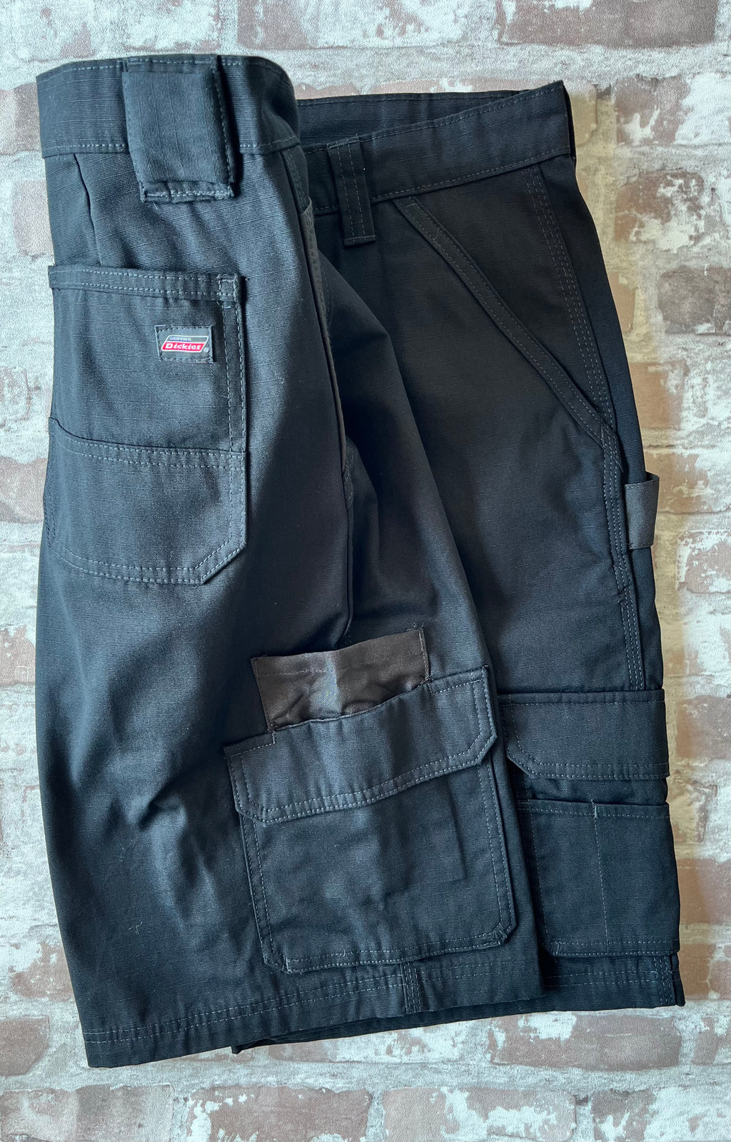 Short cargo noir en toile Ripstop Genuine Dickies avec boucle marteau et poches latérales à soufflets, présenté à plat.