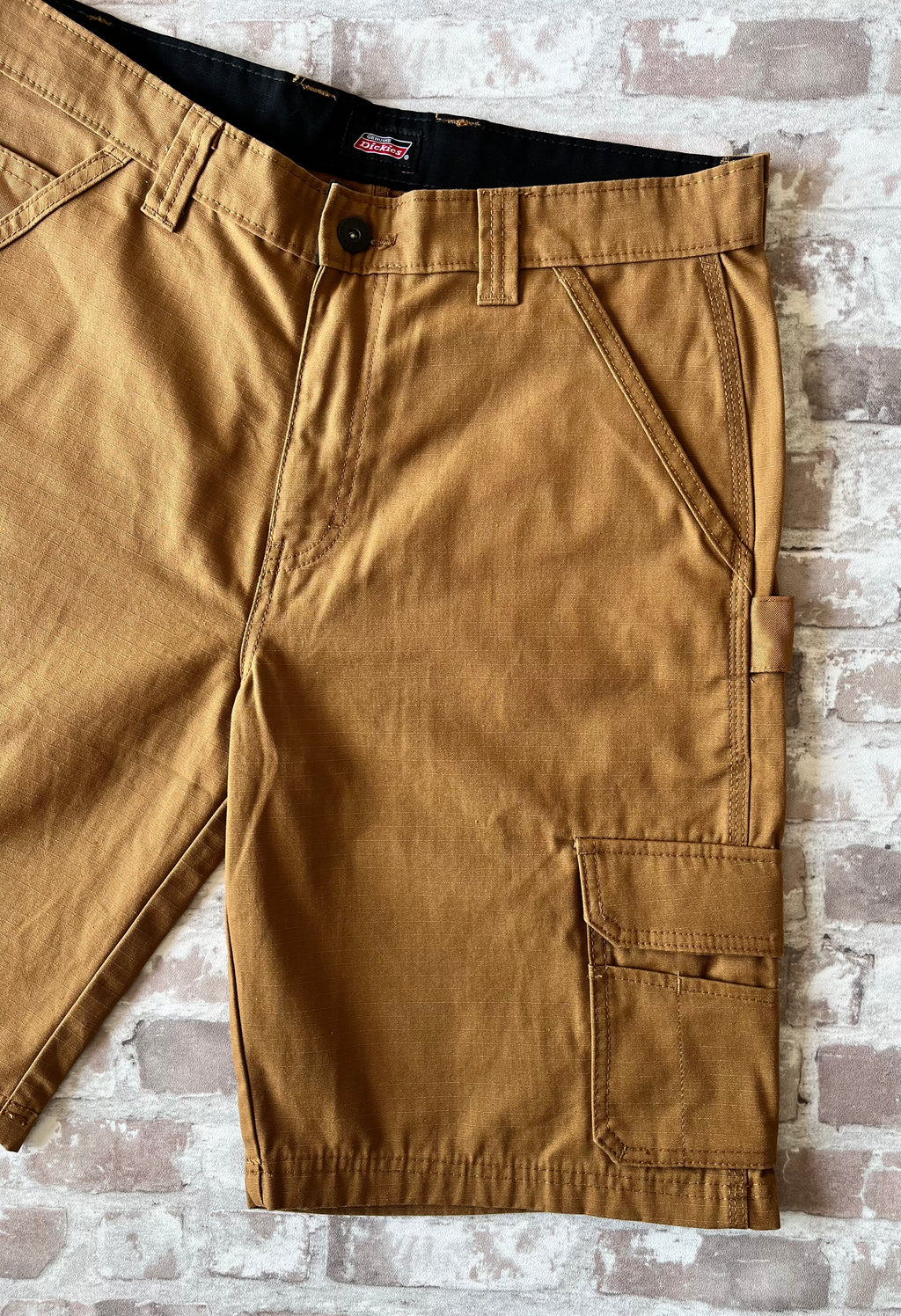 Short cargo marron Dickies en toile de coton Duck Canvas avec boucle marteau et poches à soufflets, présenté à plat.