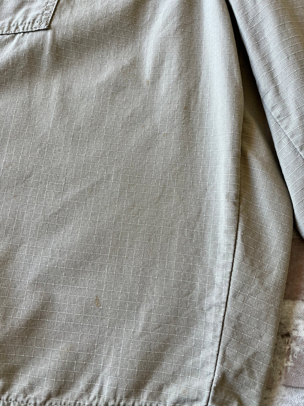 Gros plan sur les taches colorées authentiques de la toile d'un bermuda Dickies beige de seconde main.