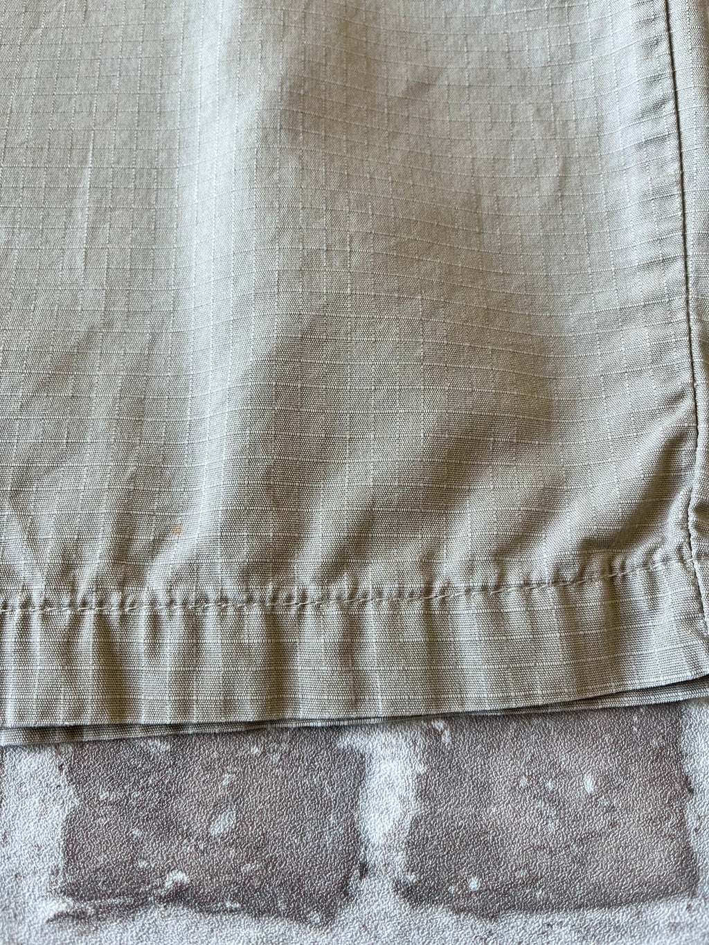 Gros plan sur les taches colorées authentiques de la toile d'un bermuda Dickies beige de seconde main.