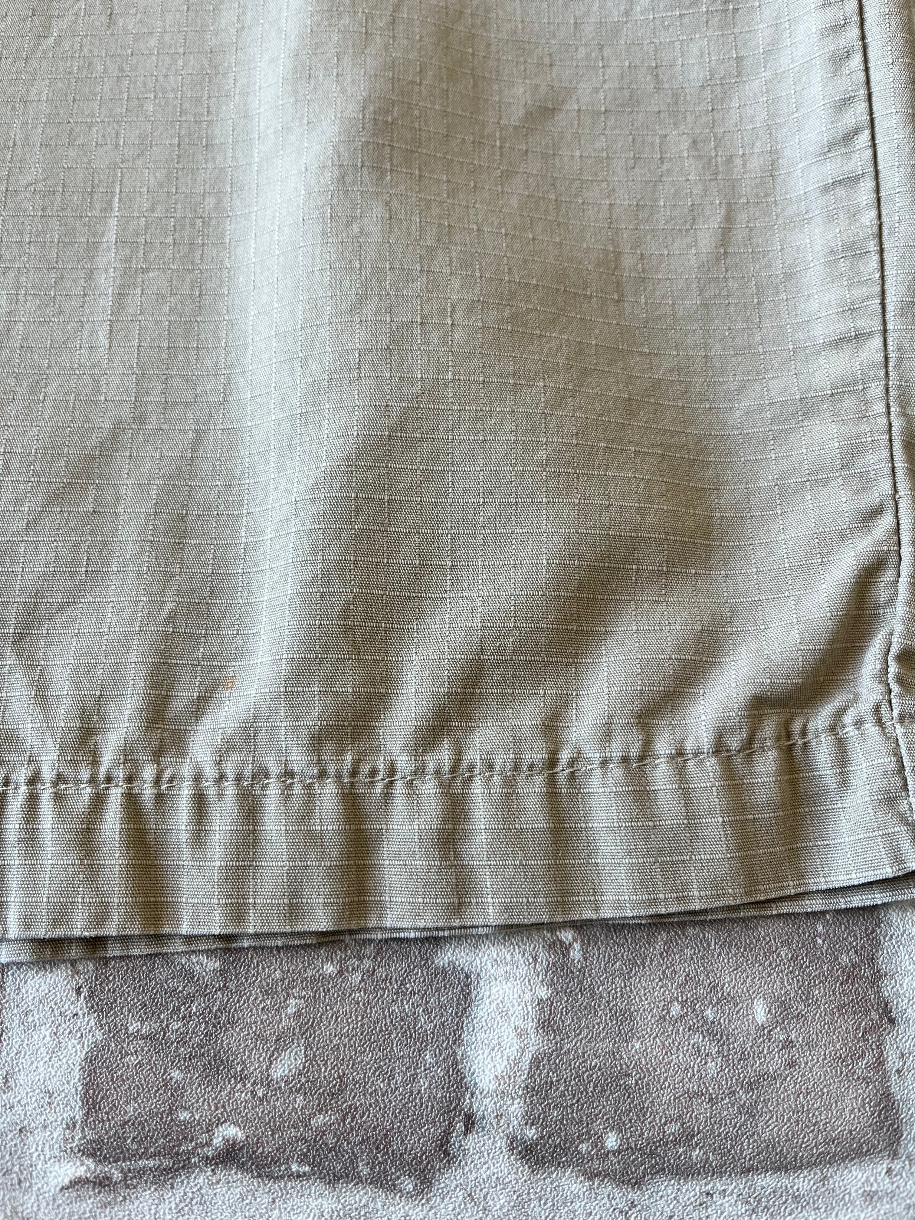 Gros plan sur les taches colorées authentiques de la toile d'un bermuda Dickies beige de seconde main.