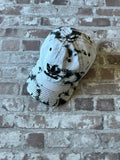 Casquette dad hat Adidas Originals au motif tie-dye marbré noir et blanc avec logo trèfle brodé, présentée à plat.