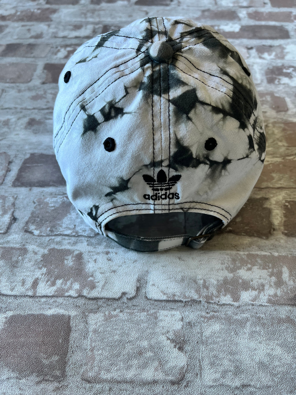 Casquette dad hat Adidas Originals au motif tie-dye marbré noir et blanc avec logo trèfle brodé, présentée à plat, vue arrière