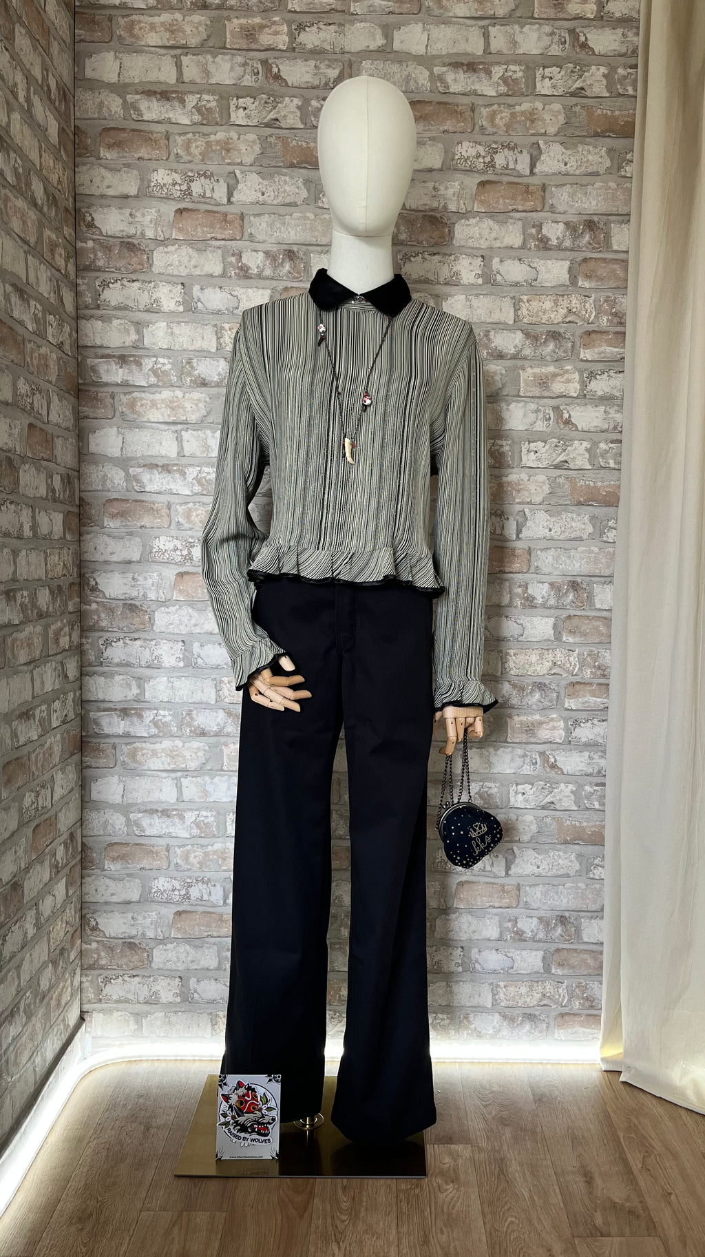 Pantalon rigide noir Dickies 874 porté par un mannequin femme avec un chemisier vintage Chikuma à rayures et col claudine noir.