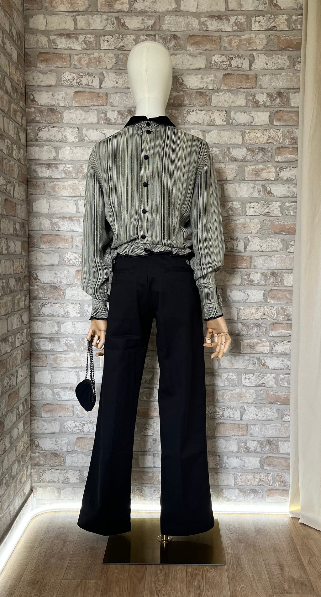 Pantalon rigide noir Dickies 874 porté par un mannequin femme avec un chemisier vintage Chikuma à rayures et col claudine noir, de dos
