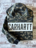 Sweat à capuche vintage Carhartt avec imprimé camouflage kaki et beige, grand logo blanc central sur la poitrine, présenté à plat, plié