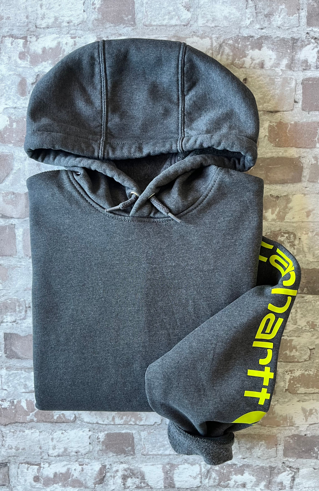 Sweat à capuche vintage Carhartt K288 gris anthracite Carbon Heather avec écusson cousu sur la poche kangourou avant, présenté à plat, plié