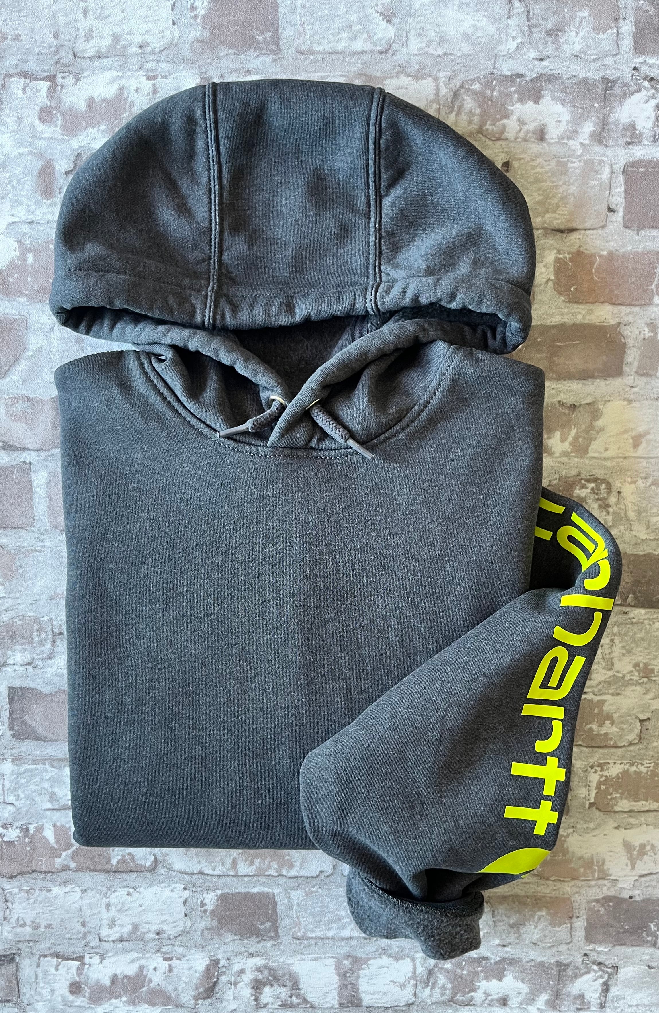 Sweat à capuche vintage Carhartt K288 gris anthracite Carbon Heather avec écusson cousu sur la poche kangourou avant, présenté à plat, plié