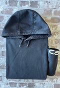 Sweat à capuche noir Carhartt K288 Heavyweight à patine décolorée avec écusson de la marque sur la poche kangourou, présenté à plat, plié