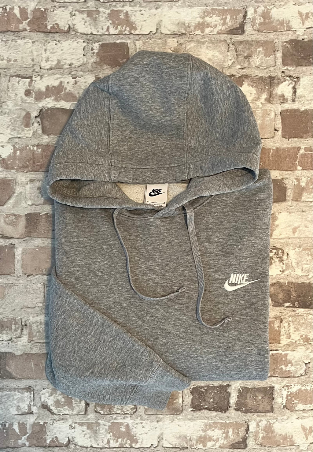 Sweat à capuche vintage Nike gris chiné Heather Grey avec logo Futura brodé en blanc sur la poitrine, présenté à plat, plié