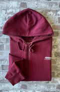 Sweat à capuche zippé vintage Genuine Dickies couleur bordeaux maroon avec logo poitrine et étiquette de la marque sur la poche, présenté à plat, plié