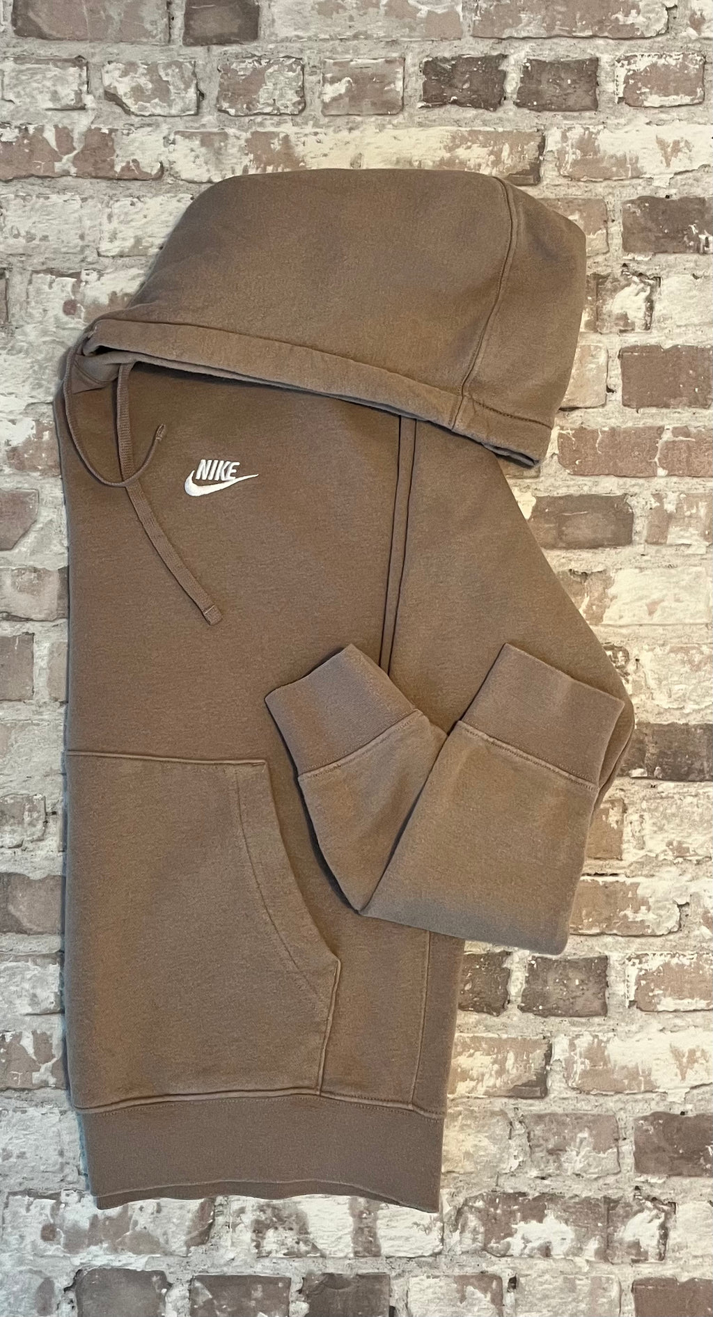 Sweat à capuche Nike Club Fleece couleur beige sable clair avec logo Futura brodé sur la poitrine, présenté plié à plat, de profil