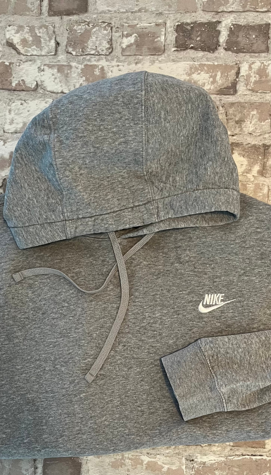 Sweat à capuche vintage Nike gris chiné Heather Grey avec logo Futura brodé en blanc sur la poitrine, présenté à plat.