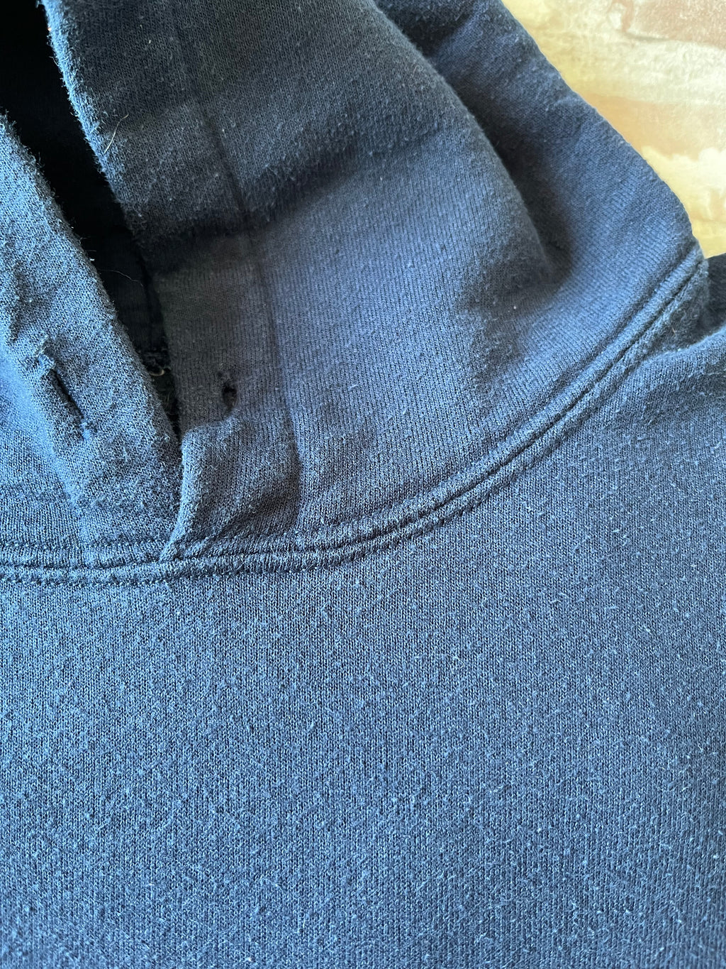Sweat à capuche vintage bleu marine Ryerson Rams avec écusson bélier brodé et grand lettrage RU en satin jaune, présenté plié à plat, focus cordons absents et patine coton