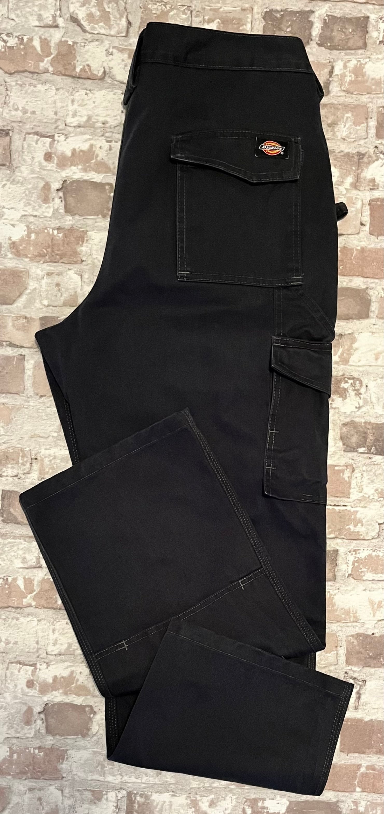 Pantalon cargo technique noir Dickies avec poches utilitaires à rabat et renforts aux genoux, présenté à plat 