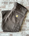 Pantalon en coton stretch marron foncé Carhartt Rugged Flex avec poches outils latérales, présenté à plat, plié