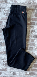 Pantalon de travail vintage Dickies 874 Original Fit noir avec pli permanent et patch logo à l'arrière, présenté plié à plat.