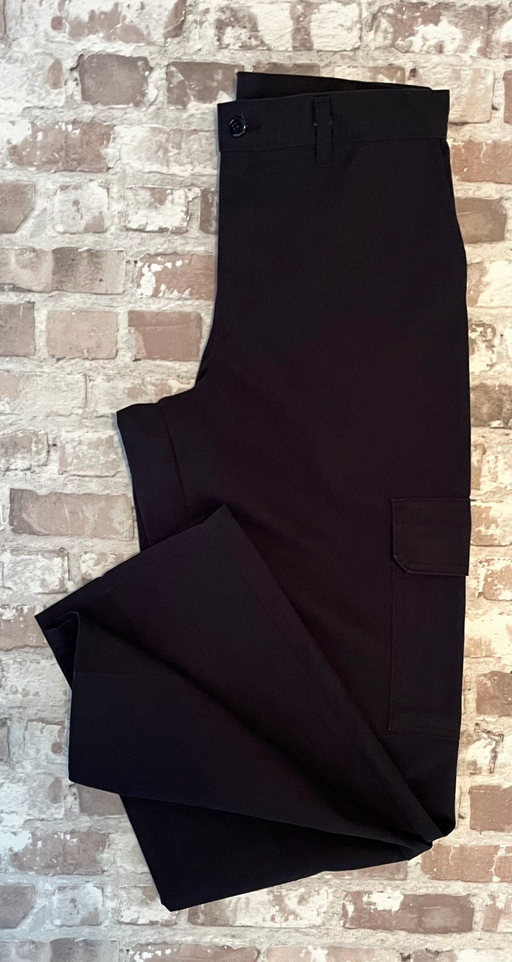 Pantalon cargo Dickies droit noir avec poches latérales à rabats velcro et pli permanent, présenté plié à plat.