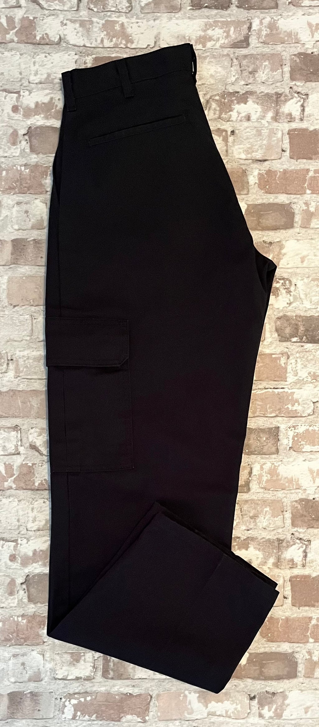 Pantalon cargo Dickies droit noir avec poches latérales à rabats velcro et pli permanent, présenté plié à plat.
