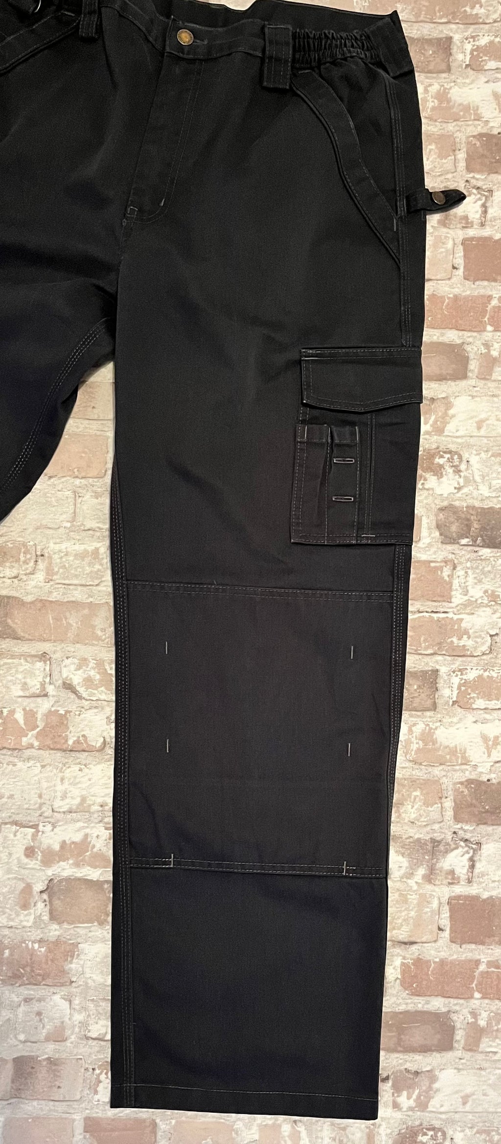 Pantalon cargo technique noir Dickies avec poches utilitaires à rabat et renforts aux genoux, présenté à plat de face.