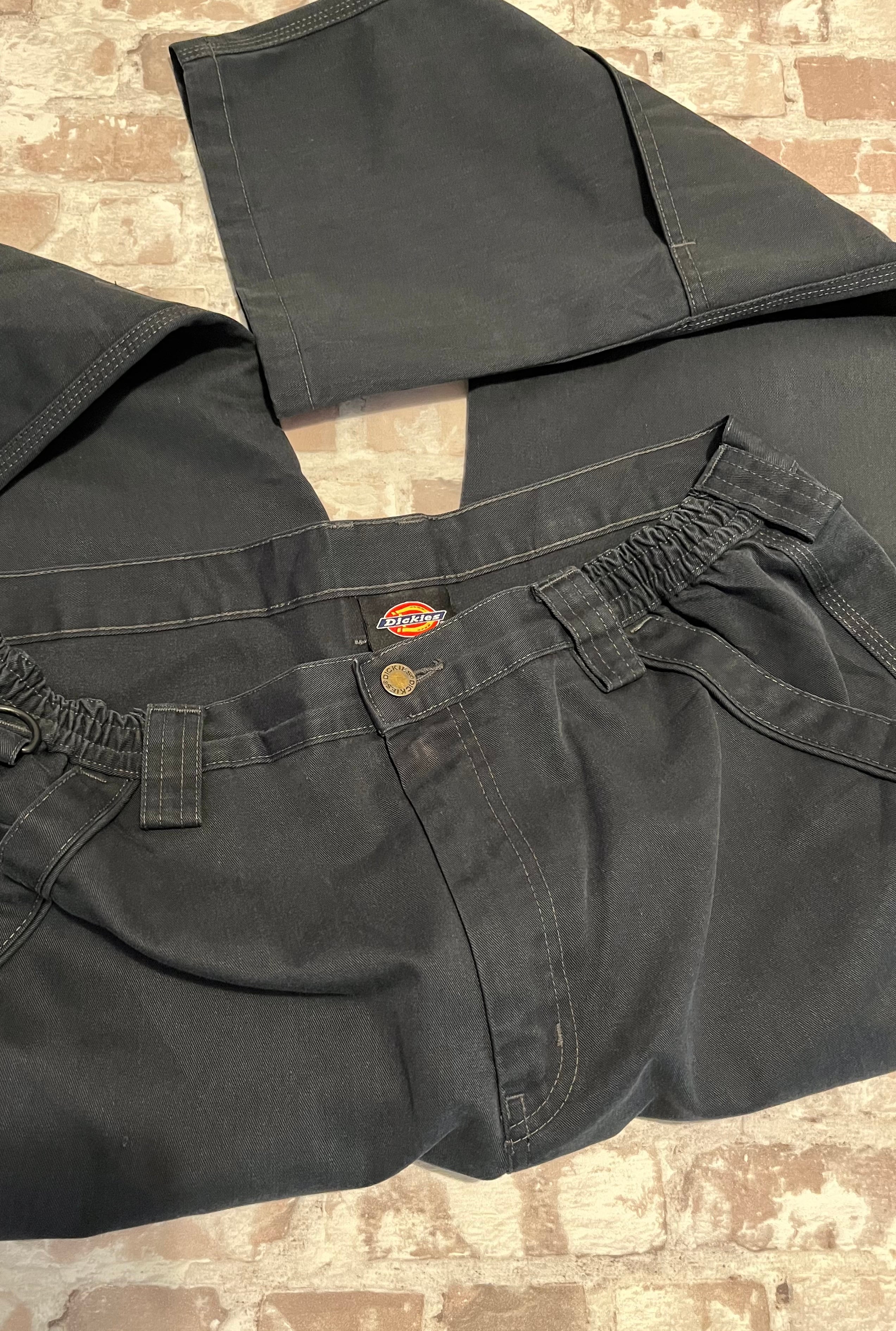 Gros plan sur la ceinture élastique d'un pantalon cargo noir Dickies.