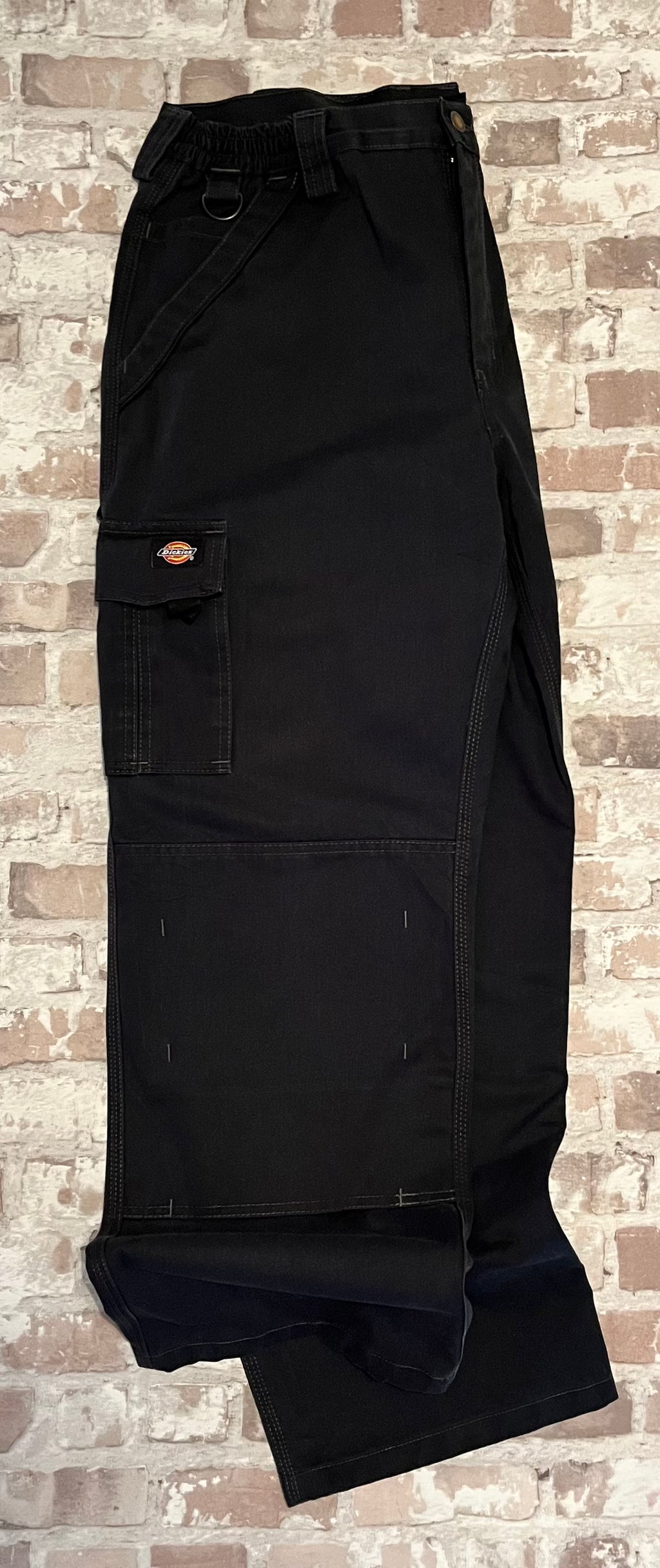 Pantalon cargo technique noir Dickies avec poches utilitaires à rabat et renforts aux genoux, présenté à plat 