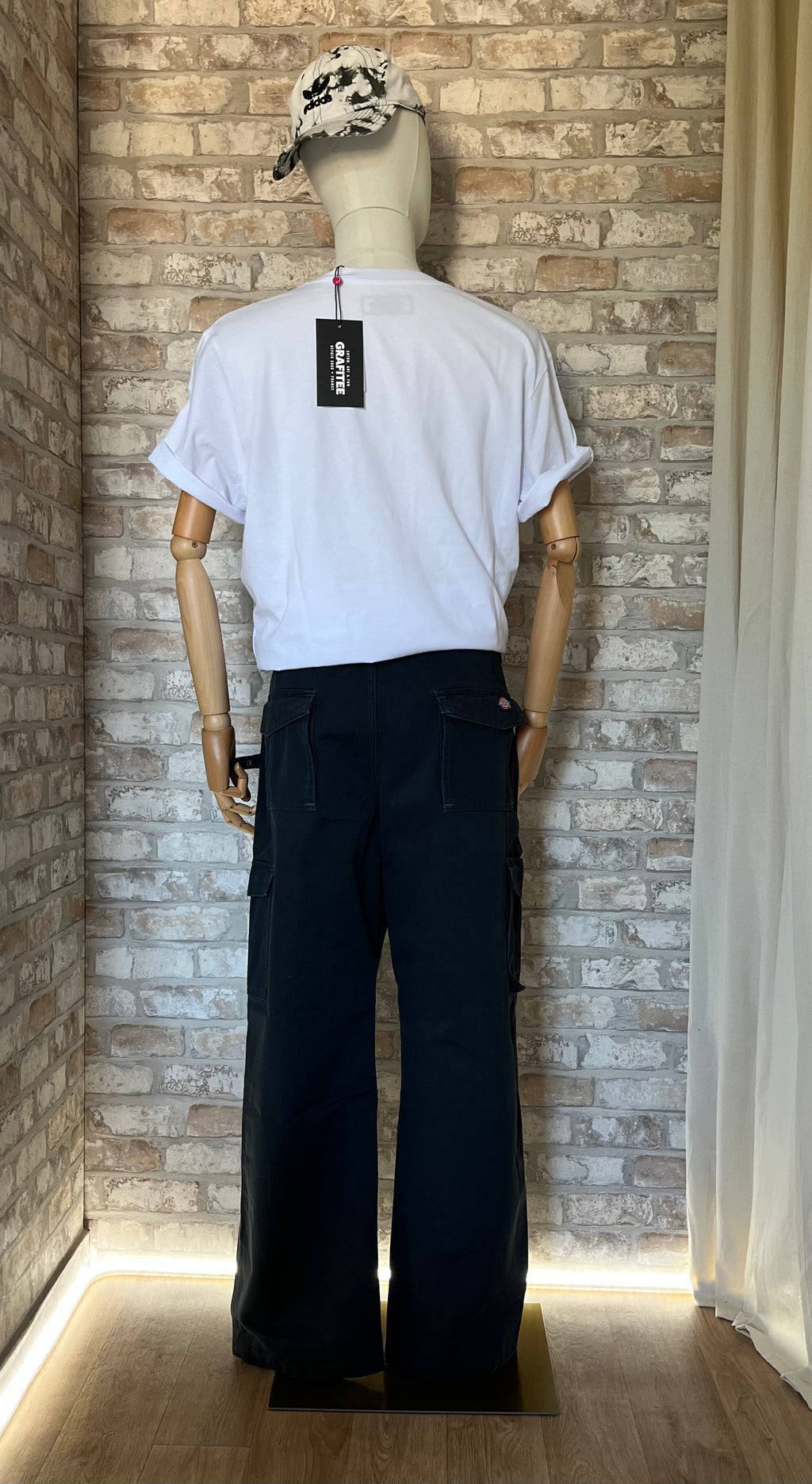 Pantalon Cargo Technique Dickies  Noir-Bleu style Workwear Authentique porté par un mannequin, de dos, avec un tshirt Grafitee et une casquette vintage Adidas
