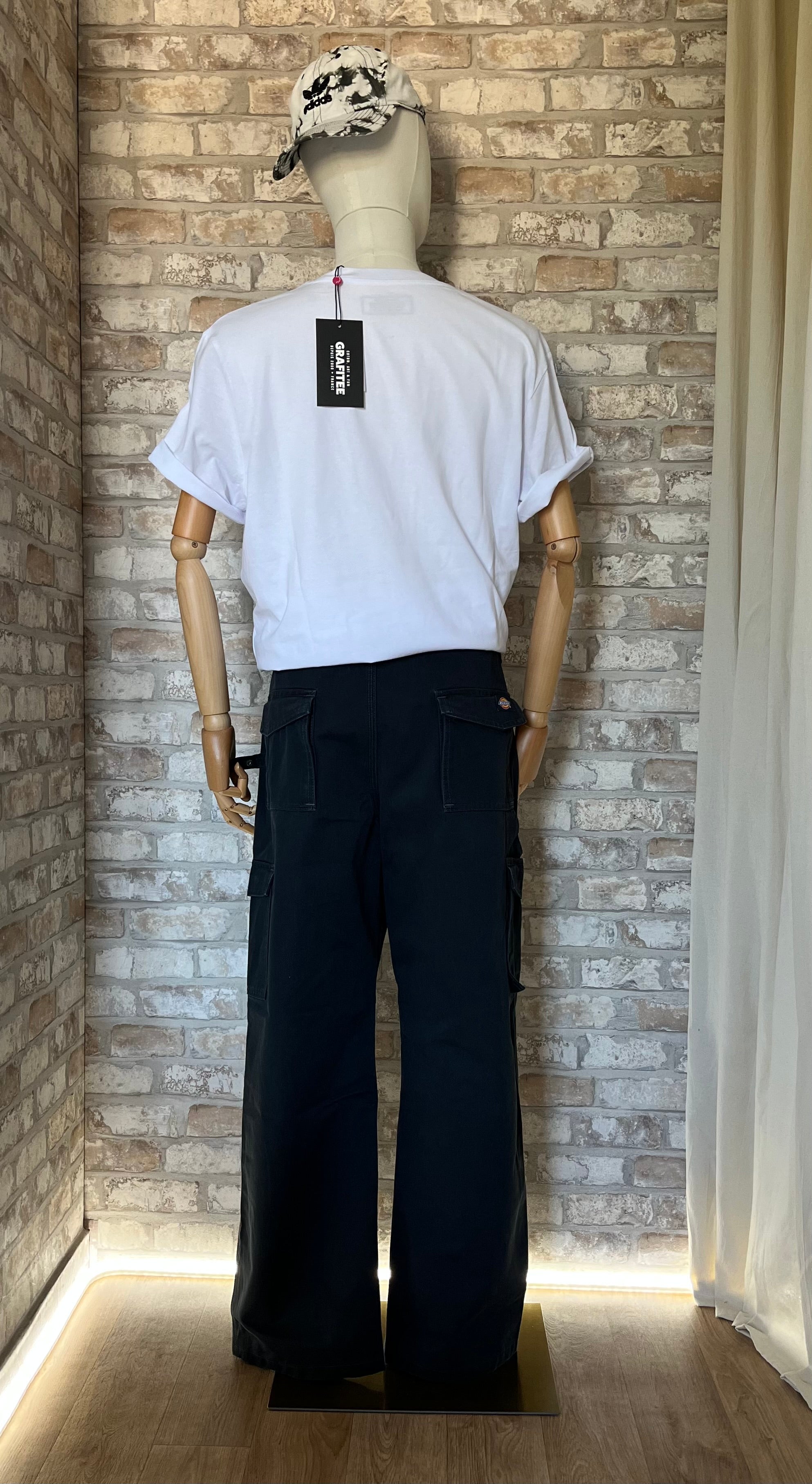 Pantalon Cargo Technique Dickies  Noir-Bleu style Workwear Authentique porté par un mannequin, de dos, avec un tshirt Grafitee et une casquette vintage Adidas