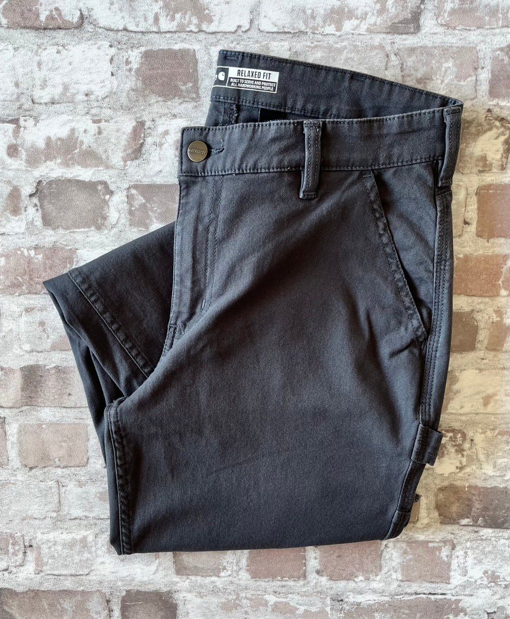 Pantalon de travail gris anthracite femme Carhartt Carpenter avec bas de jambes coupés à cru, présenté à plat, plié