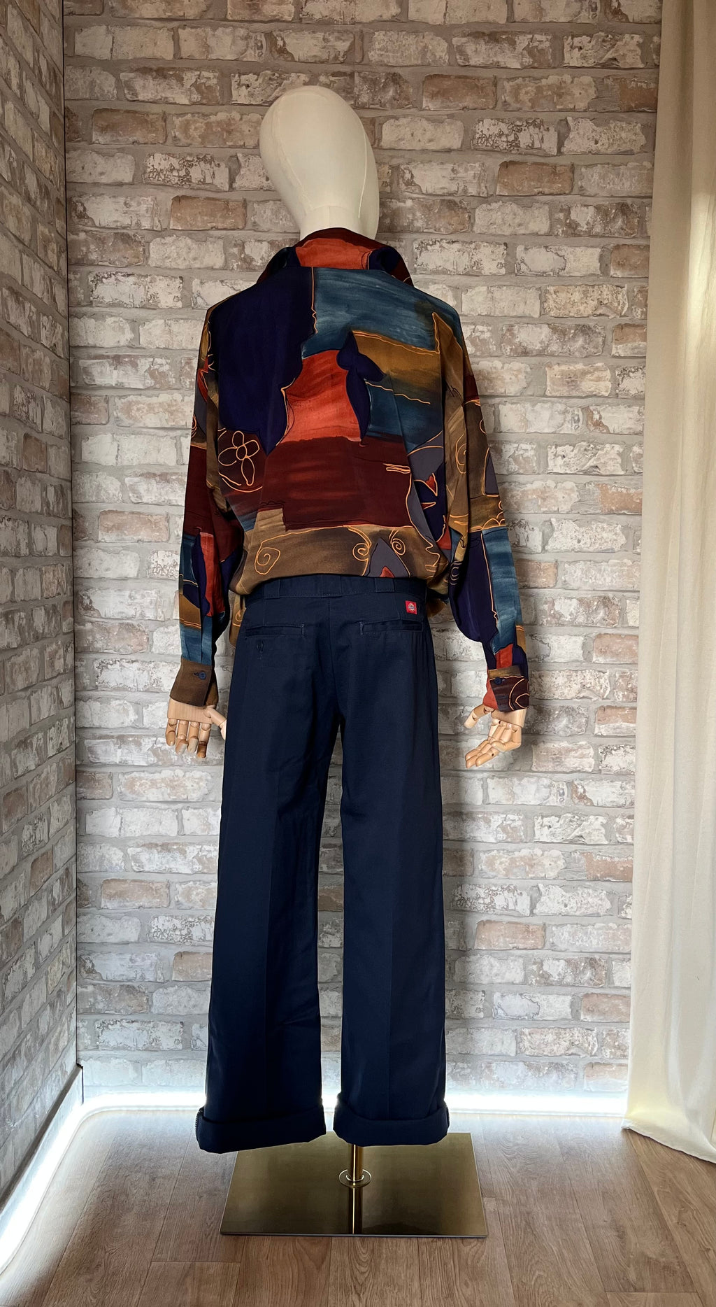 Pantalon droit bleu marine Dickies 774 pour femme porté en lookbook avec une chemise de couturier Christian Aujard, de dos